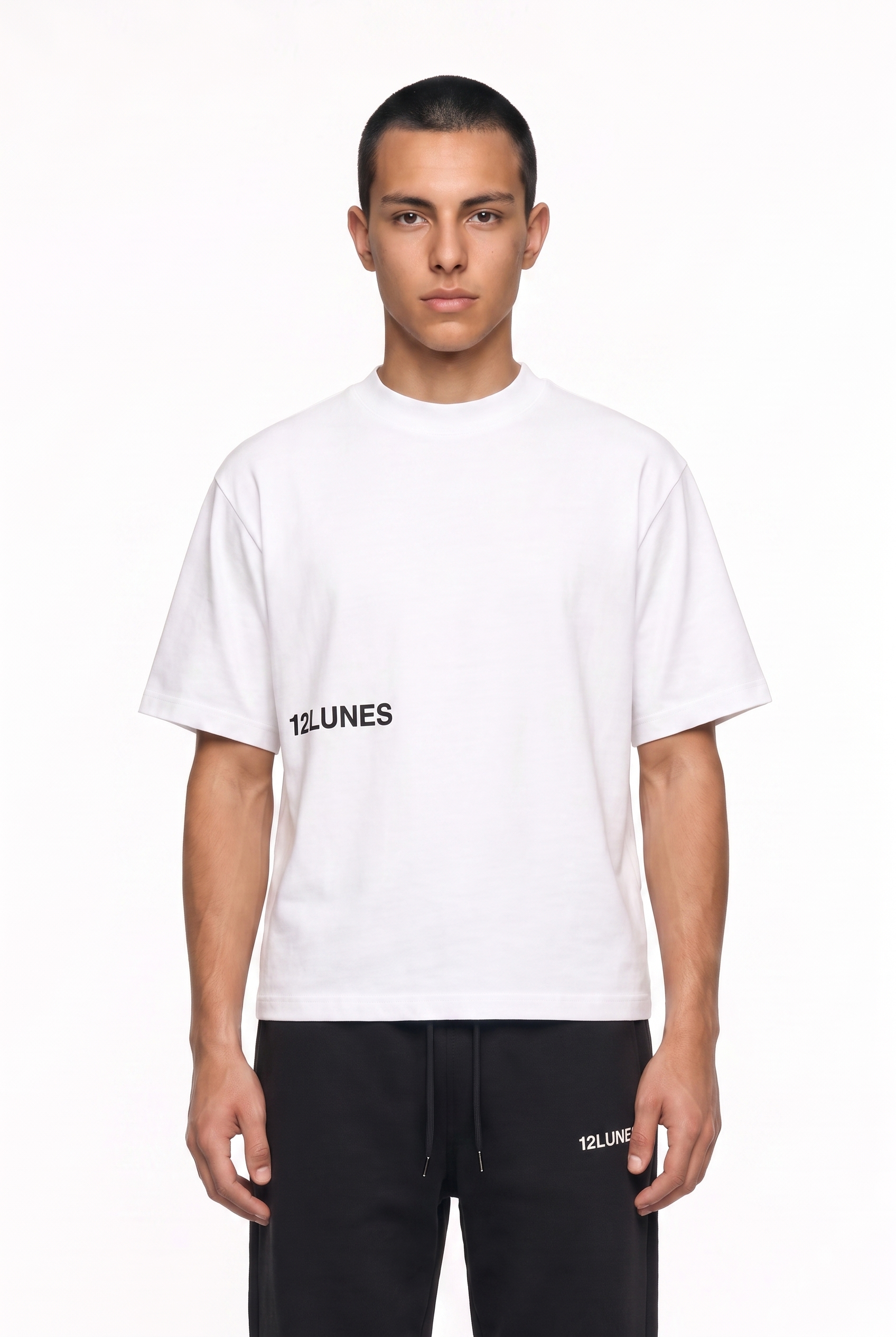 Homme portant le tee-shirt blanc 12LUNES boxy crop et le trackpant noir