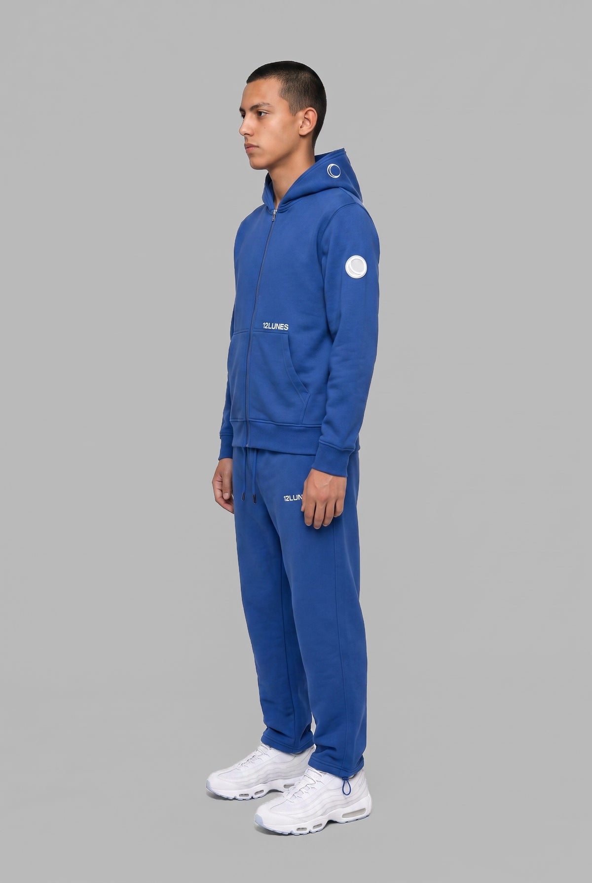 Full-Zip Cobalt 12LUNES, sweat zippé à capuche bleu porté avec le Trackpant Cobalt, vu de trois quarts